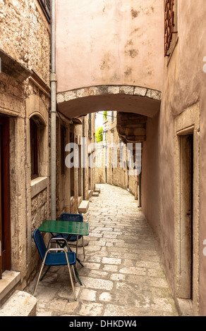 Table et chaises dans la rue étroite de Korcula, Croatie Banque D'Images