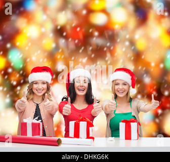 Smiling women in santa helper chapeaux avec les coffrets cadeaux Banque D'Images