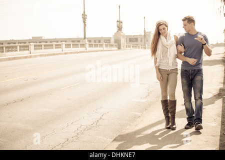 Jeune Couple marchant sur un pont dans la ville Banque D'Images