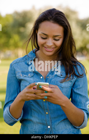 Portrait en extérieur d'une magnifique africaine-américaine à l'envoi d'un sms Banque D'Images
