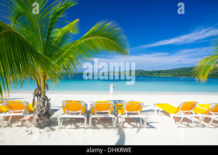 Chaises de plage vide s'asseoir sur la plage tropicale en attente de passagers en croisière. L'Acajou Bay, Roatan Banque D'Images