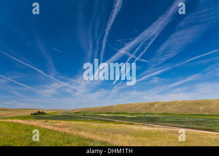 Flyover country, avec traînées à travers le vaste ciel bleu, sur une voie de chemin de fer parallèle à l'autoroute 2 Nebraska Banque D'Images