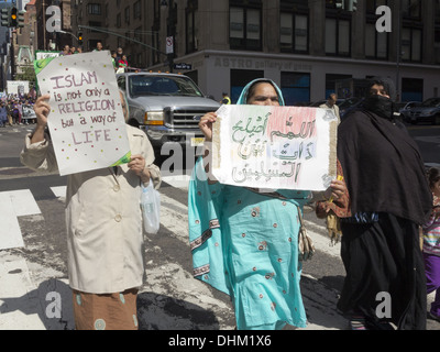 Musulman annuel Day Parade, New York City, 2013. Les femmes portent des signes, en anglais et en arabe, qui vantent les vertus de l'Islam. Banque D'Images