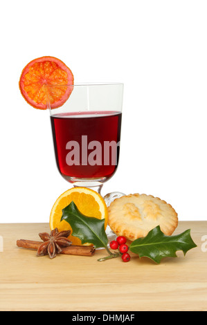 Vin chaud, mince pie et de houx sur une planche de bois sur un fond blanc. Banque D'Images