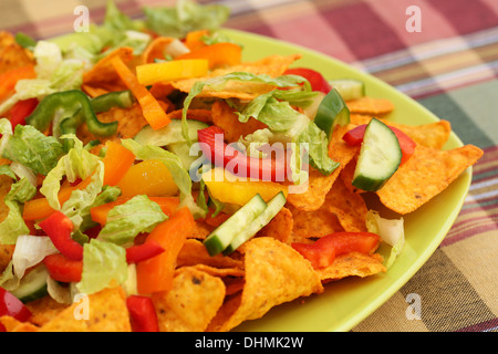 Tas de nachos avec légumes sur plaque verte. Banque D'Images