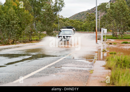 Traversée d'un 4X4 rouge sur une route inondée. Banque D'Images