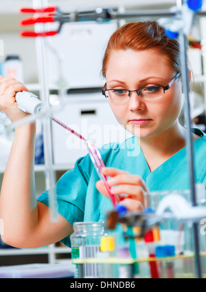 Tech femelle ou scientifique travaille avec pipette in biological laboratory Banque D'Images