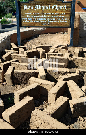 Signe de l'église San Miguel et briques adobes séchant au soleil au cours de projet de restauration, Santa Fe, Nouveau Mexique USA Banque D'Images