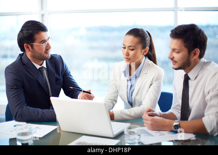 Portrait of young businessman presenting nouveau projet dans son portable au bureau de coleagues Banque D'Images