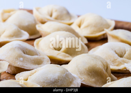 Arrière-plan de pétrole brut russe pelmeni disposés sur une planche à découper Banque D'Images