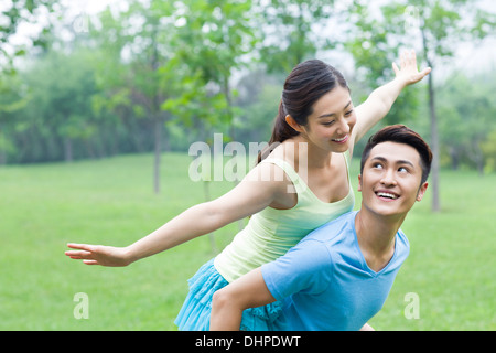 Jeune homme donnant à son amie un piggy back ride Banque D'Images