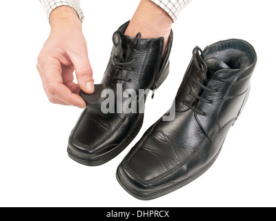 Le polissage de l'homme chaussures noires, isolated on white background, studio shot Banque D'Images