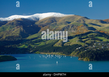 Lyttelton Harbour, yachts amarrés par Diamond Harbor township, et la neige sur la péninsule de Banks, Christchurch, Canterbury, Nouvelle-Zélande Banque D'Images