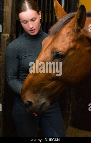 Femme donner une friandise à cheval, format vertical Banque D'Images