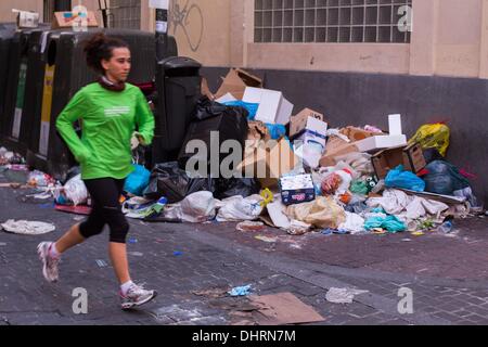 Madrid, Espagne. Nov 9, 2013. Une femme devant des tas de détritus dans le centre de Madrid, le 9 novembre 2013. Les nettoyeurs de rues et les collecteurs de déchets parc public jardiniers travaillant pour la ville de Madrid a commencé une grève le 5 novembre 2013, appelé par les syndicats contre les licenciements et des baisses de salaire. Les sociétés de nettoyage de la ville de Madrid plan pour ax autour de 1 000 emplois et de réduire les salaires de 40 pour cent.Photo : Alvaro Hurtado/NurPhoto NurPhoto © Alvaro Hurtado//ZUMAPRESS.com/Alamy Live News Banque D'Images