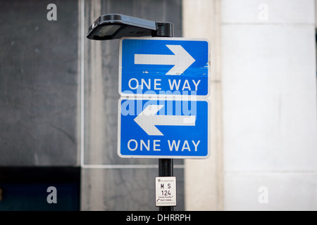 Deux panneaux de circulation montés l'un au-dessus de l'autre mais les deux pointant dans des directions opposées. Londres, Royaume-Uni. Banque D'Images