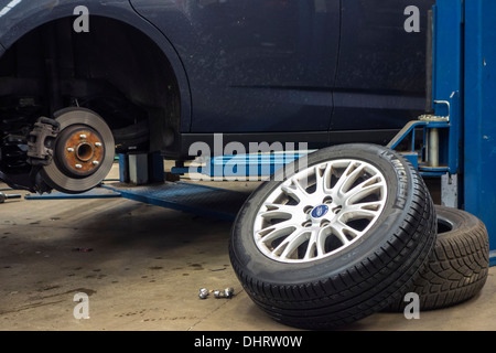 L'évolution des pneus d'été et le montage des pneus d'hiver sur roues du wagon sur la rampe d'accès à l'atelier de montage de pneu Banque D'Images