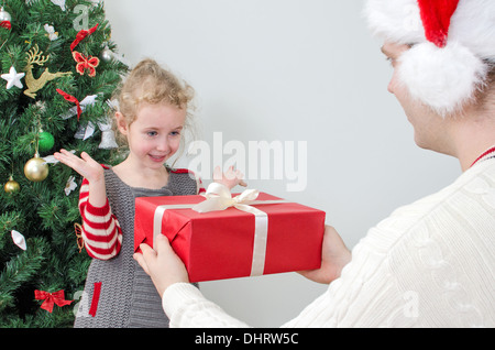 Père surprenant petite fille avec des cadeaux de Noël Banque D'Images