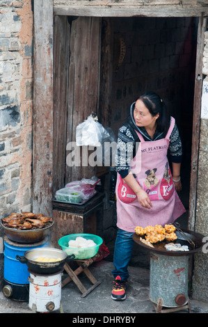 La cuisson des aliments de rue femme dans Hongcun Heritage Village à Huizhou, région de l'Anhui Banque D'Images