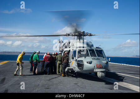 Mer des Philippines (nov. 15, 2013) Les marins à bord de la Marine américaine déployée sur l'avenir, le porte-avions USS George Washington (CVN 73) conteneurs d'eau sur un MH-60S Seahawk de la 'Golden Falcon' de la mer d'hélicoptères de l'Escadron de Combat (HSC) à l'appui de l'opération 12 Damayan. Le George Washington grève groupe soutient la 3e brigade expéditionnaire de marines pour aider le gouvernement des Philippines en réponse à la suite de la super typhon Haiyan/Yolanda dans la République des Philippines. (U.S. Photo de la Marine) Crédit : Foto 23/Alamy Live News Banque D'Images