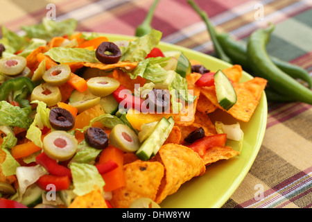 Tas de nachos avec légumes sur plaque verte. Banque D'Images