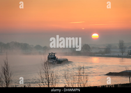 Pays-bas, Lopik, toits de village près de la rivière Lek. Inland barge cargo. Le lever du soleil. L'hiver Banque D'Images