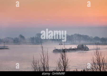 Pays-bas, Lopik, Lek river. Inland barge cargo. Le lever du soleil. L'hiver Banque D'Images