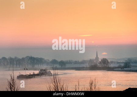 Pays-bas, Lopik, toits de village près de la rivière Lek. Inland barge cargo. Le lever du soleil. L'hiver Banque D'Images