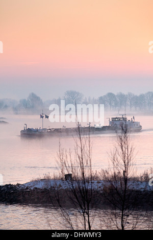 Pays-bas, Lopik, Lek river. Inland barge cargo. Le lever du soleil. L'hiver Banque D'Images
