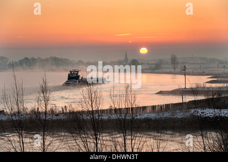 Pays-bas, Lopik, toits de village près de la rivière Lek. Inland barge cargo. Le lever du soleil. L'hiver Banque D'Images