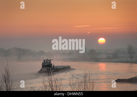 Pays-bas, Lopik, toits de village près de la rivière Lek. Inland barge cargo. Le lever du soleil. L'hiver Banque D'Images