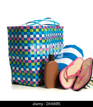 Un sac de plage avec une serviette, crème solaire et des tongs rose sur fond blanc Banque D'Images