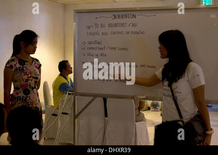 International Convention Centre, Cebu City 16/11/2013. Une initiative de la ville de Cebu impliquant un certain nombre d'organismes gouvernementaux à la suite du typhon Haiyan/Yolanda. A 24h de l'aide d'opération concerne la réception et le reconditionnement des produits alimentaires destinés aux régions les plus durement touchées. Les bénévoles sont principalement des étudiants. Packs de secours contenant 6 kilos de riz,5 boîtes de sardines,5 boîtes de corned beef/pain de viande bovine. Banque D'Images