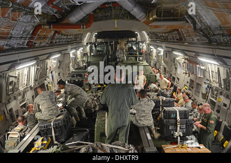 Aviateurs de la 36e Groupe d'intervention d'urgence et 535e Escadron de transport aérien situer leurs bagages eux-mêmes et sur leurs sièges le 15 novembre 2013, sur l'Andersen Air Force Base, Guam, flightline avant le départ de l'aéronef pour appuyer l'opération à Damayan Tacl Banque D'Images