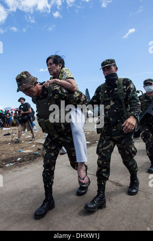 Soldats de l'armée philippine d'aider une personne âgée à un local philippins en attente pour le transport à Manille au Banque D'Images