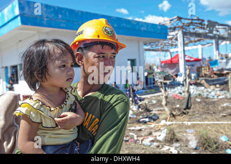 Un soldat de l'armée philippine est titulaire d'un enfant déplacé par le typhon Haiyan en attente d'un avion pour l'évacuation à Manille le 15 novembre 2013 à la base aérienne de Tacloban, Philippines. Banque D'Images