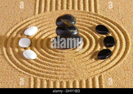 Jardin zen japonais avec des pierres empilées du yin et yang en sable ratissée Banque D'Images