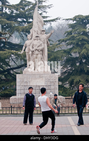 Les hommes jouer jeu Jianzi en face de la statue dans le parc Dongdan révolutionnaire de Dongcheng District, Beijing, Chine Banque D'Images