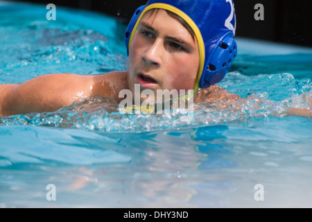 Teenage Boy dans un match de water-polo preuve de détermination Banque D'Images