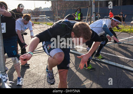 Battersea, Londres, Royaume-Uni. 16 novembre 2013. Négocier un concurrents de chaînes web La santé des hommes au cours de la survie du plus fort de l'événement 2013 à Battersea Power Station. Crédit : Paul Davey/Alamy Live News Banque D'Images