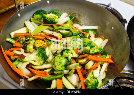 Le brocoli carottes tranchées chayotte Plantain Squash les choux de Bruxelles dans un wok pour un sauté le dîner Banque D'Images