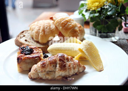 Image Gros plan feuille de pain aux bananes et pain grillé dans un plat blanc de petit-déjeuner. Banque D'Images