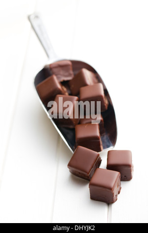 Pralines au chocolat sur metal scoop sur table en bois blanc Banque D'Images