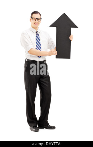 Portrait d'un jeune homme souriant tenant une grande flèche noire pointant vers le haut Banque D'Images