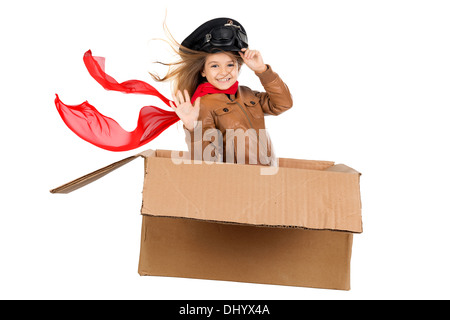 Jeune fille pilote aux commandes d'une boîte en carton blanc en isolé Banque D'Images
