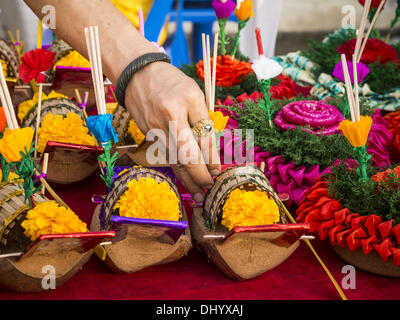 Bangkok, Thaïlande. 17 novembre, 2013. Un Krathong vendeur met de l'encens et des bougies dans les Krathongs illumines il vend près de Wat Yannawa à Bangkok. Loy Krathong (également écrit Loi Krathong) est célébrée chaque année dans toute la Thaïlande et dans certaines parties du Laos et de la Birmanie (dans l'État Shan). Le nom peut être traduit ''couronne flottante'' ou ''Décoration Flottante'' et vient de la tradition de fabrication de décorations flottants qui sont ensuite lancées sur une rivière. Banque D'Images