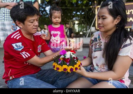 Bangkok, Thaïlande. 17 novembre, 2013. Une famille prie devant leur flottante krathong dans la rivière Chao Phraya à Wat Loy Krathong sur Yannawa à Bangkok. Loy Krathong (également écrit Loi Krathong) est célébrée chaque année dans toute la Thaïlande et dans certaines parties du Laos et de la Birmanie (dans l'État Shan). Le nom peut être traduit ''couronne flottante'' ou ''Décoration Flottante'' et vient de la tradition de fabrication de décorations flottants qui sont ensuite lancées sur une rivière. Banque D'Images