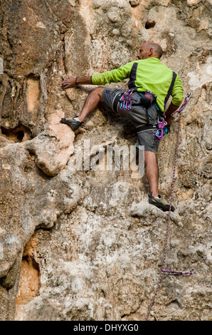 Un homme en face d'un mur de pierre à la recherche de la meilleure route, l'escalade à Mijas, Costa del Sol, Espagne. Banque D'Images