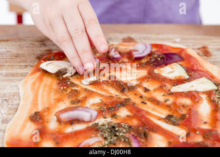 Les petites mains préparation des pizzas. studio shot. Banque D'Images