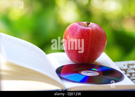 De pomme mûre, de dvd et livre ouvert Banque D'Images